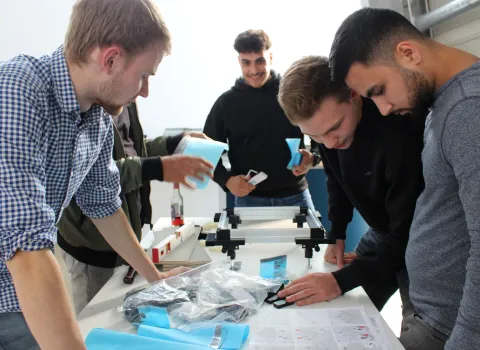 Eine Gruppe Auszubildender an der Werkbank.